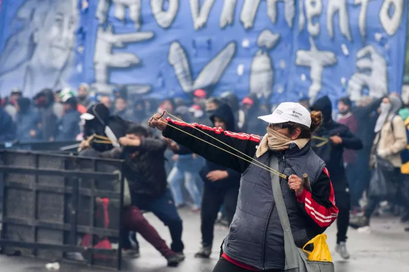 a demonstrator in argentina fires a slingshot at riot police outside congress ahead of a vote photo afp a demonstrator in argentina fires a slingshot at riot police outside congress ahead of a vote photo afp