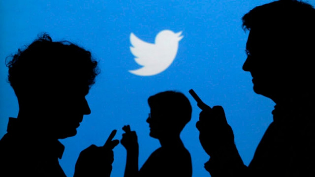 people holding mobile phones are silhouetted against a backdrop projected with the twitter logo in this illustration picture taken in warsaw photo reuters