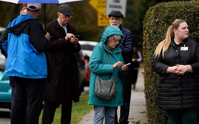 by standers check their phones outside of a synagogue after the pittsburgh shooting photo afp