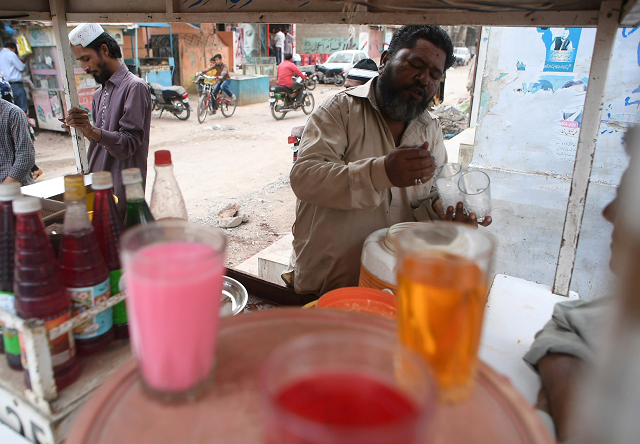 faluda seller mohammad qadir prepares drinks for customers at his cart in orangi town photo afp