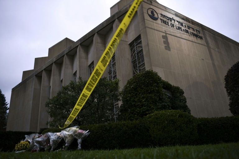 police tape and memorial flowers on october 28 2018 outside the tree of life synagogue after a shooting there left 11 people dead in the squirrel hill neighborhood of pittsburgh pennsylvania photo afp