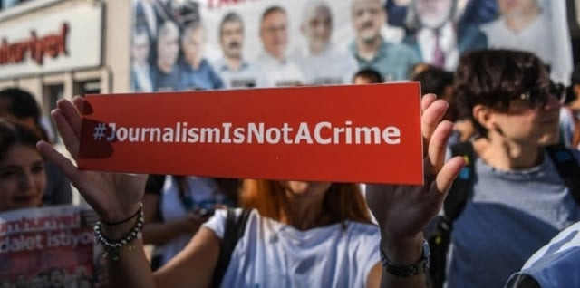a journalist holds a banner photo afp a journalist holds a banner photo afp