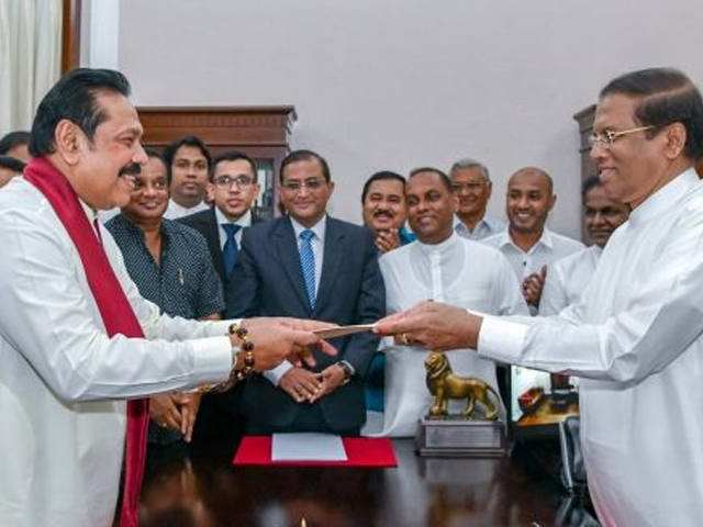 sri lanka s former president mahinda rajapaksa left is sworn in as the new prime minister before president maithripala sirisena in colombo on friday photo sri lanka s president s office via reuters