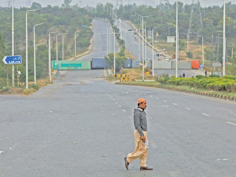 a man walks across a deserted road near faizabad in islamabad photo reuters