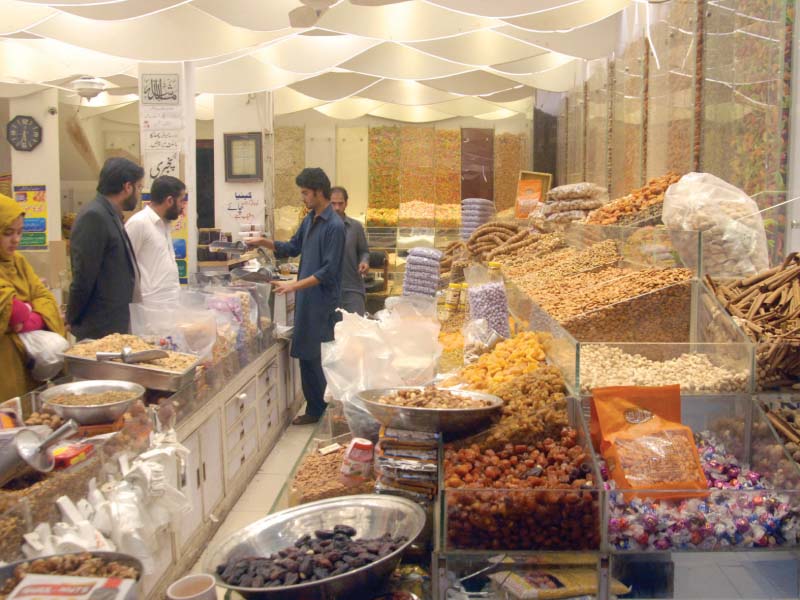 people buy dry fruits from a shop photo express