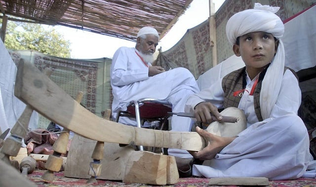 a young boy makes a traditional baloch musical instrument during the 039 artisan at work 039 festival at lok virsa photo online a young boy makes a traditional baloch musical instrument during the 039 artisan at work 039 festival at lok virsa photo online