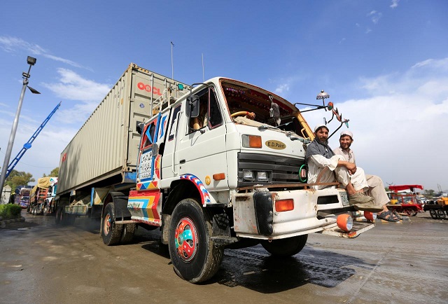 file photo afghan men sit in front of supply trucks carrying containers for export at the customhouse in jalalabad afghanistan may 14 2018 photo reuters