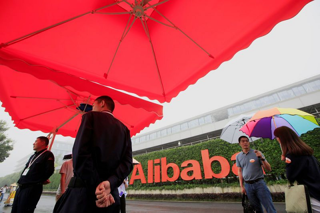 people stand near a sign of alibaba group at its campus in hangzhou zhejiang province china may 27 2016 photo reuters