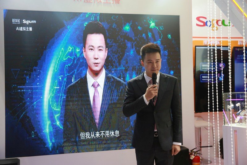 xinhua news anchor qiu hao stands next to an ai virtual news anchor based on him at a sogou booth during an expo at the fifth world internet conference wic in wuzhen photo reuters