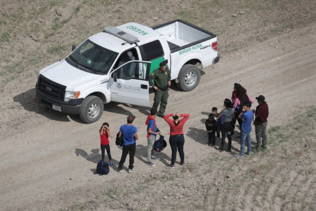 asylum seekers turn themselves in to a us border patrol agent after crossing from mexico into the united states photo reuters asylum seekers turn themselves in to a us border patrol agent after crossing from mexico into the united states photo reuters