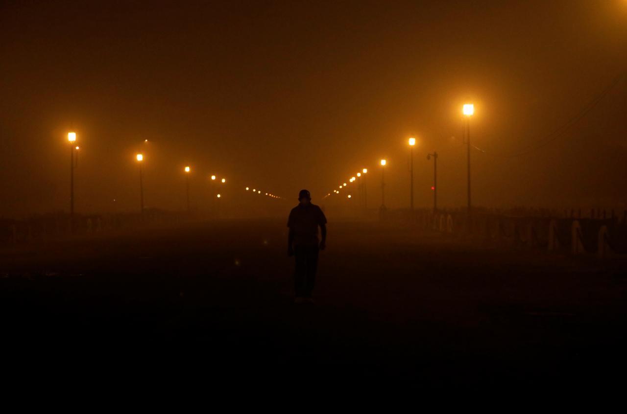 a man wearing a protective mask walks amidst smog in the early morning in new delhi india photo reuters