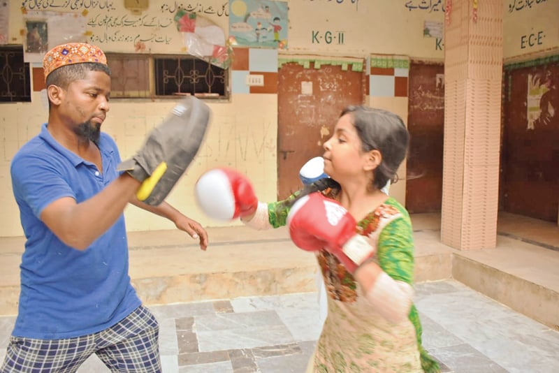 a young girl throws punches at a boxing club in lyari in recent years avenues for extracurricular activities have seen an upsurge in the neighbourhood photo courtesy zuleikha dawood