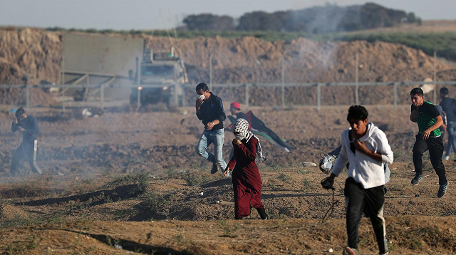 palestinians run from tear gas fired by israeli troops during a protest calling for lifting the israeli blockade on gaza at the israel gaza border fence in gaza november 2 2018 photo reuters