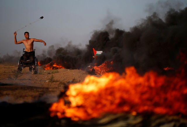 a disabled palestinian uses a sling to hurl stones at israeli troops during a protest calling for lifting the israeli blockade on gaza and demanding the right to return to their homeland at the israel gaza border fence east of gaza city photo reuters