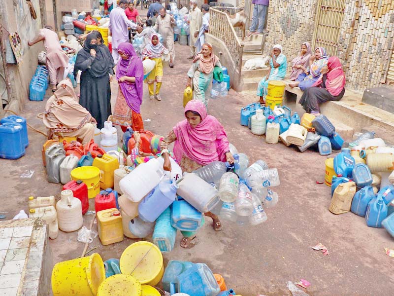 citizens wait in line for their turn to fill cans with potable water many areas of lyari have been deprived of water for the past two decades photo online