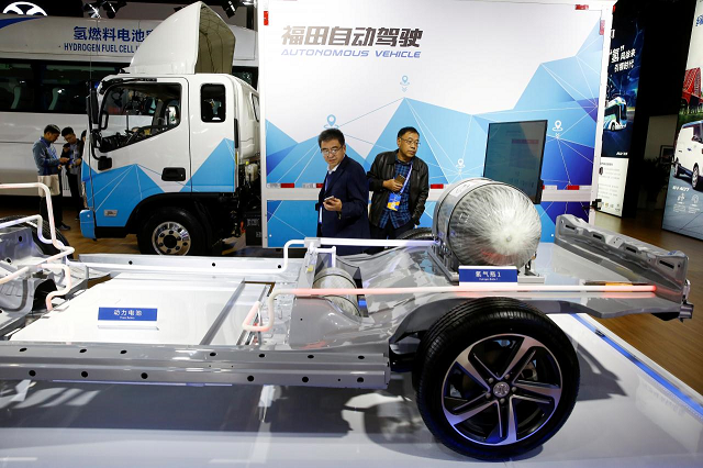 visitors looks at the frame of an electric vehicle next to a foton autonomous truck at the stall of the baic group automobile maker at the ieev new energy vehicles exhibition in beijing china october 18 2018 photo reuters