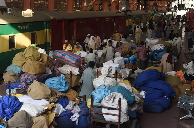 postal workers load mail into a train carriage at a railway station during world post day in lahore on october 9 2018 photo afp