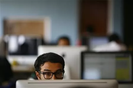 an employee works on his computer at a office photo reuters an employee works on his computer at a office photo reuters