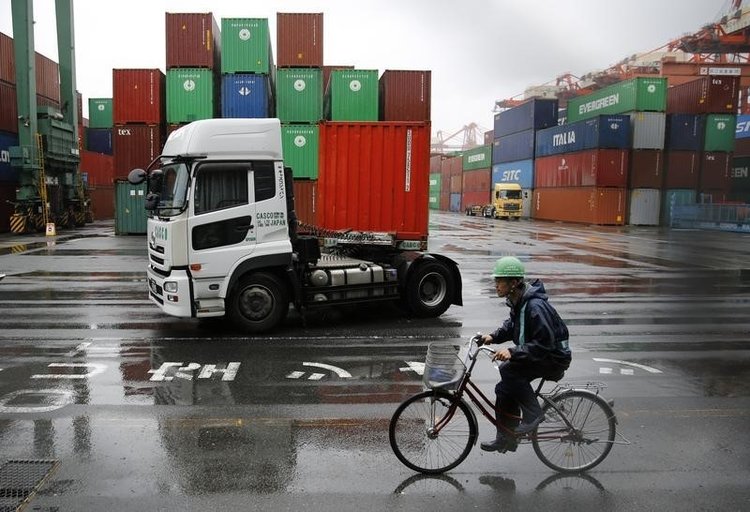 a worker rides a bicycle in a container area at a port photo reuters