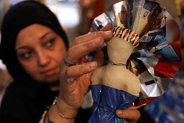 a woman decorates traditional sugar candy in the shape of a doll at a street market ahead of mawlid al nabi the birthday of holy prophet muhammad pbuh in cairo egypt november 12 2018 picture taken november 12 2018 reuters