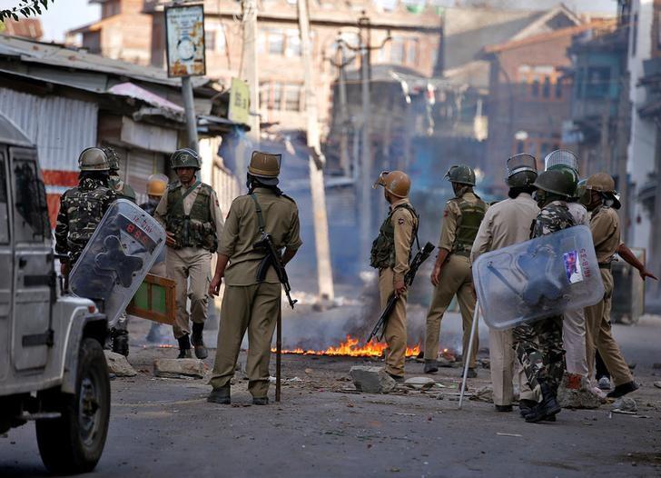 indian policemen stand next to a burning handcart photo reuters