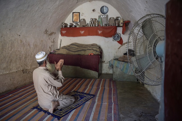 pakistani villager faqeer gul offers noon prayers in his cave room in nikko village about 60 kilometres from the capital islamabad near the highway town hasan abdal photo afp
