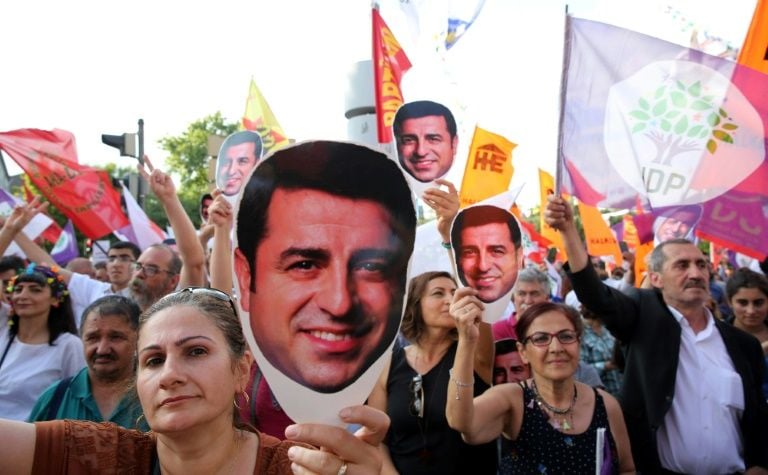 supporters of imprisoned pro kurdish leader selahattin demirtas hold masks as they march during a rally in ankara turkey photo afp