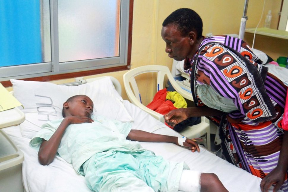 a woman talks to a child injured when italian volunteer was seized in chakama trading center of magarini as he receives treatment at the malindi district hospital in malindi kenya photo reuters