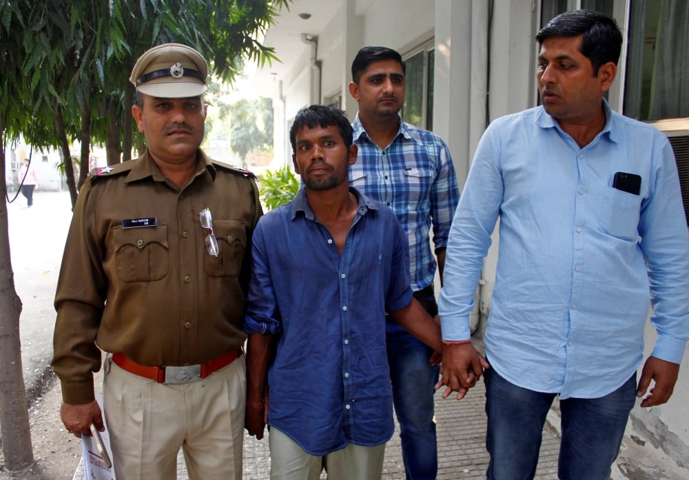 police escort a man accused of raping and killing a three year old girl outside a police station in gurugram on the outskirts of new delhi india on wednesday photo reuters