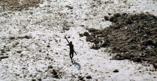 a man with the sentinelese tribe aims his bow and arrow at an indian coast guard helicopter as it flies over north sentinel island in the andamans in 2004 photo afp