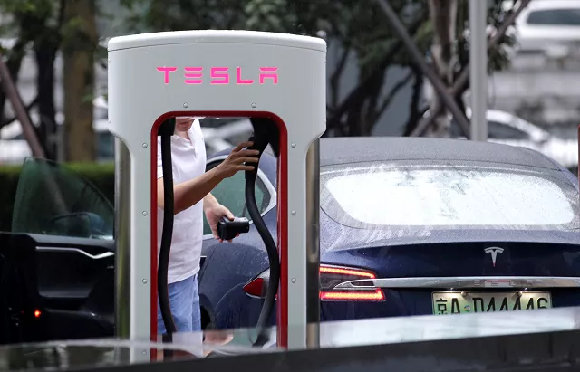 a man finishes charging his tesla car at a charging point outside tesla china headquarters in beijing china july 11 2018 photo reuters a man finishes charging his tesla car at a charging point outside tesla china headquarters in beijing china july 11 2018 photo reuters