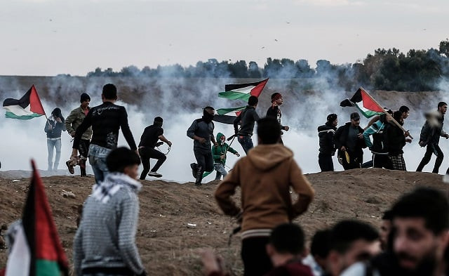 palestinians react to tear gas fired by israeli forces during a protest in the eastern outskirts of gaza city near the border with israel photo afp palestinians react to tear gas fired by israeli forces during a protest in the eastern outskirts of gaza city near the border with israel photo afp