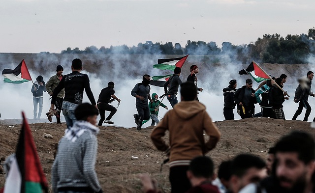 palestinians react to tear gas fired by israeli forces during a protest in the eastern outskirts of gaza city near the border with israel photo afp