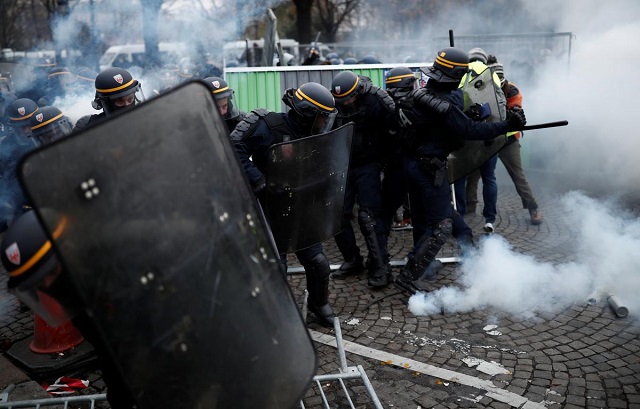 police officers fire a tear gas during protests against higher fuel prices on the champs elysee in paris france november 24 2018 reuters benoit tessier