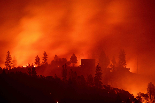 flames from the camp fire burn near a home atop a ridge near big bend california photo afp