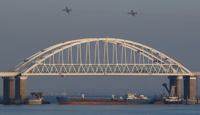 russian jet fighters fly over a bridge connecting the russian mainland with the crimean peninsula with a cargo ship beneath it after three ukrainian navy vessels were stopped by russia from entering the sea of azov via the kerch strait in the black sea crimea november 25 2018 photo reuters