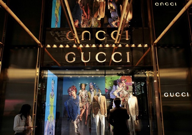 a man looks at a window display outside a gucci store part of the kering group at tsim sha tsui shopping district in hong kong january 17 2013 photo reuters