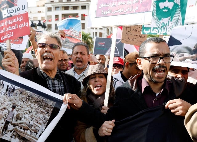 people chant slogans and hold banners as they take part in a protest opposing the visit of saudi arabia 039 s crown prince mohammed bin salman in tunis tunisia photo reuters