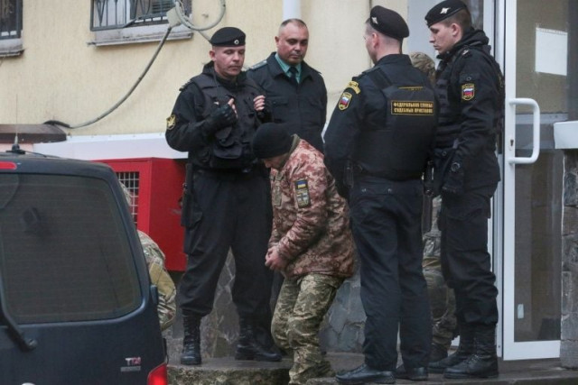 a detained ukrainian sailor is escorted to a car after a court hearing in simferopol crimea photo afp a detained ukrainian sailor is escorted to a car after a court hearing in simferopol crimea photo afp