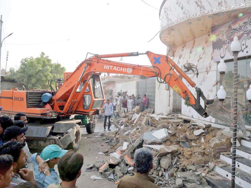 the anti encroachment operations continue on tuesday at lucknow society in korangi where stairs in front of a wedding hall are being demolished photo ppi