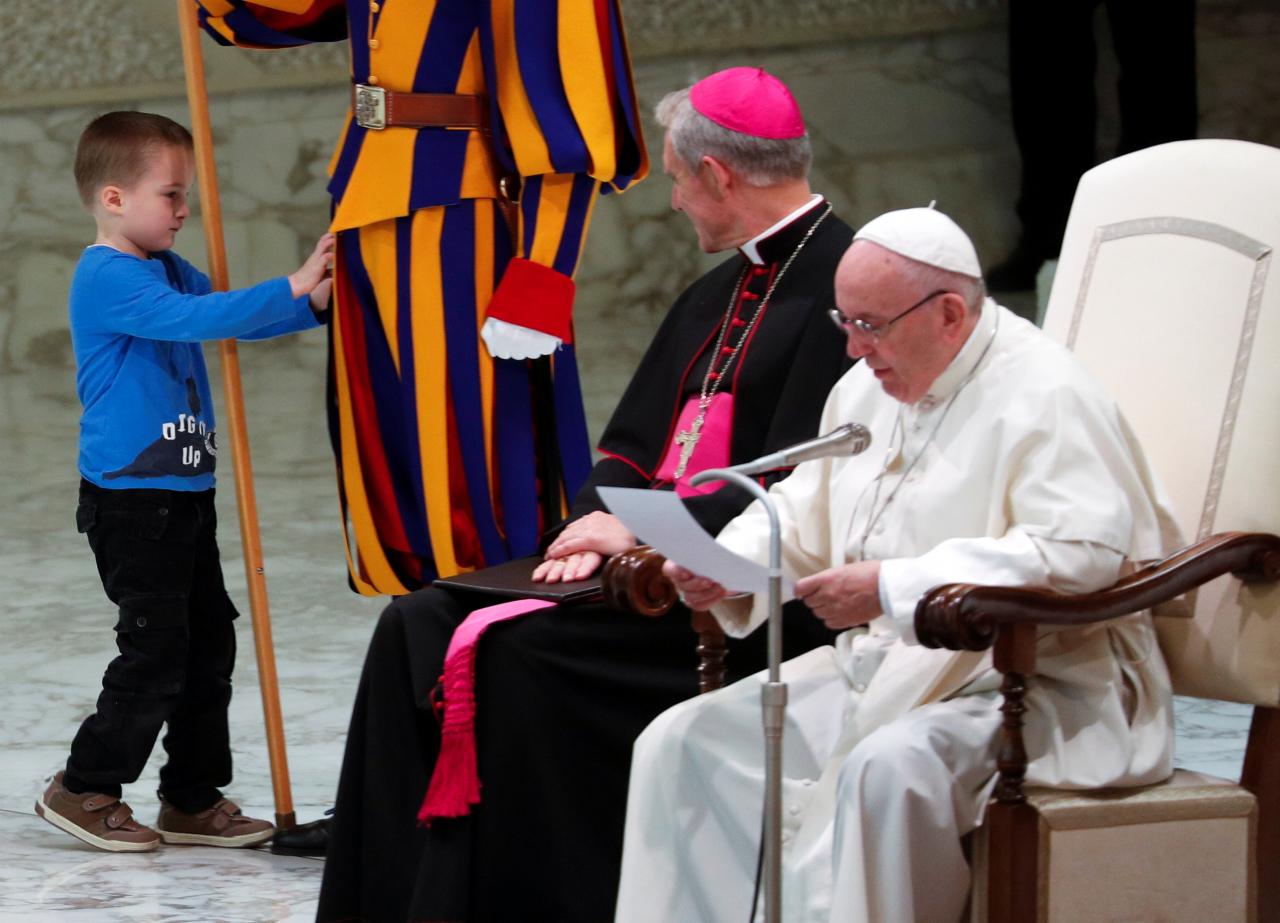 a child that escaped from his mother touches a member of swiss guard during the general audience led by pope francis at paul vi hall at the vatican photo reuters