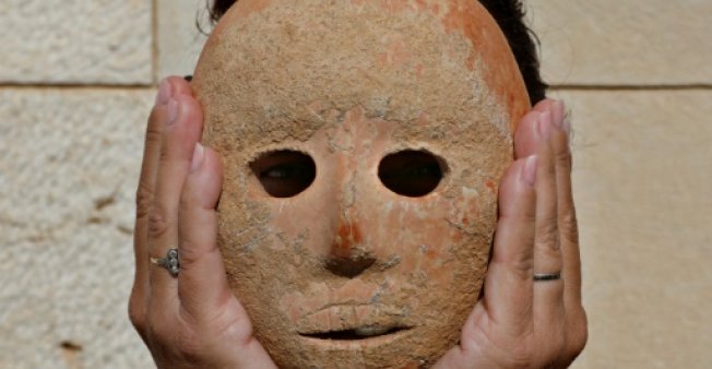 israeli archeologist ronit lupu holds a rare stone mask dating to the neolithic period which was found at the pnei hever region of southern hebron mount photo afp