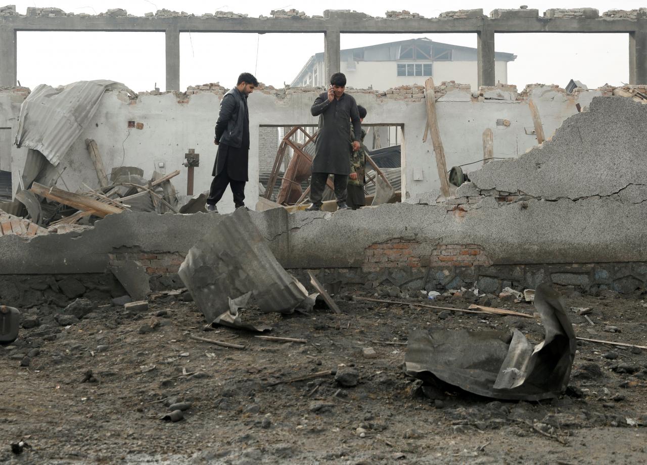 afghan men stand at the site of a car bomb attack in kabul afghanistan photo afp