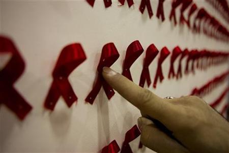 a man points at an artwork at a conceptual art exhibition about hiv aids in tehran   photo reuters