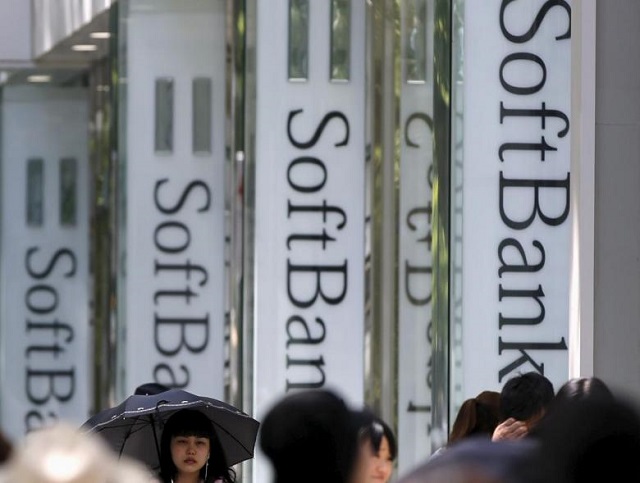 pedestrians walk past logos of softbank corp in front of its branch in tokyo may 11 2015 photo reuters