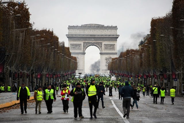 demonstrators walk near the arc de triomphe during a protest of yellow vests gilets jaunes against rising oil prices and living costs on december 1 2018 in paris photo afp demonstrators walk near the arc de triomphe during a protest of yellow vests gilets jaunes against rising oil prices and living costs on december 1 2018 in paris photo afp