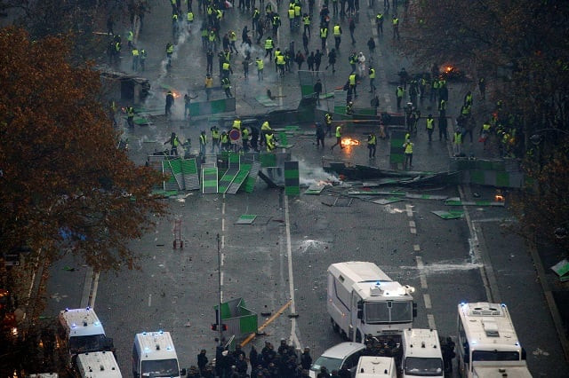 a view shows a barricade with police forces and protesters wearing yellow vests a symbol of a french drivers 039 protest against higher diesel taxes during clashes as part of a demonstration near the place de l 039 etoile in paris france december 1 2018 photo reuters