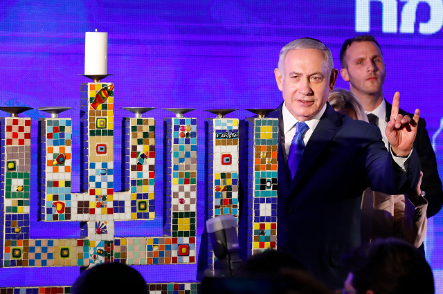 israeli prime minister benjamin netanyahu waves before lighting a stylised candle during the start of hanukkah the jewish festival of lights in ramat gan in the suburbs of the mediterranean coastal city of tel aviv on december 2 2018 photo afp