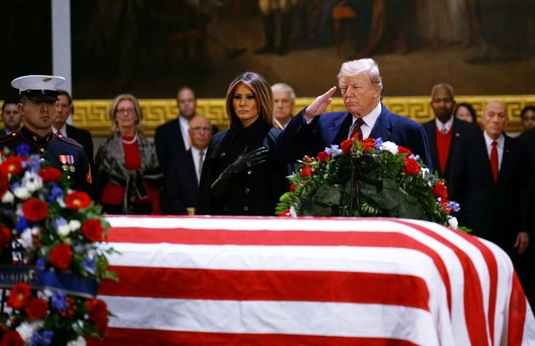 us president donald trump r and first lady melania trump pay their respects as the remains of former us president george hw bush lie in state in the us capitol photo afp