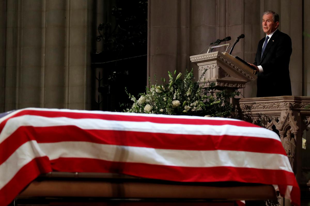 former president george w bush speaks in front of the flag draped casket of his father former president george hw bush at the state funeral at the national cathedral photo afp